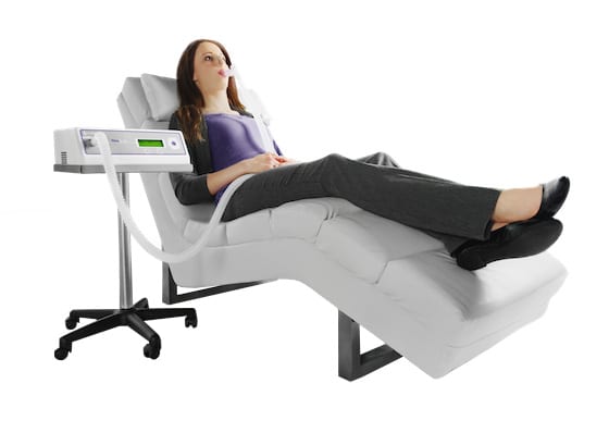 woman doing reevue test on couch next to reevue machine